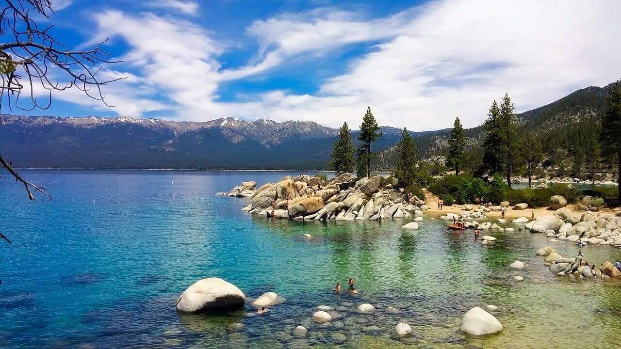 Turquoise water and rocky shoreline at Lake Tahoe surrounded by pine trees