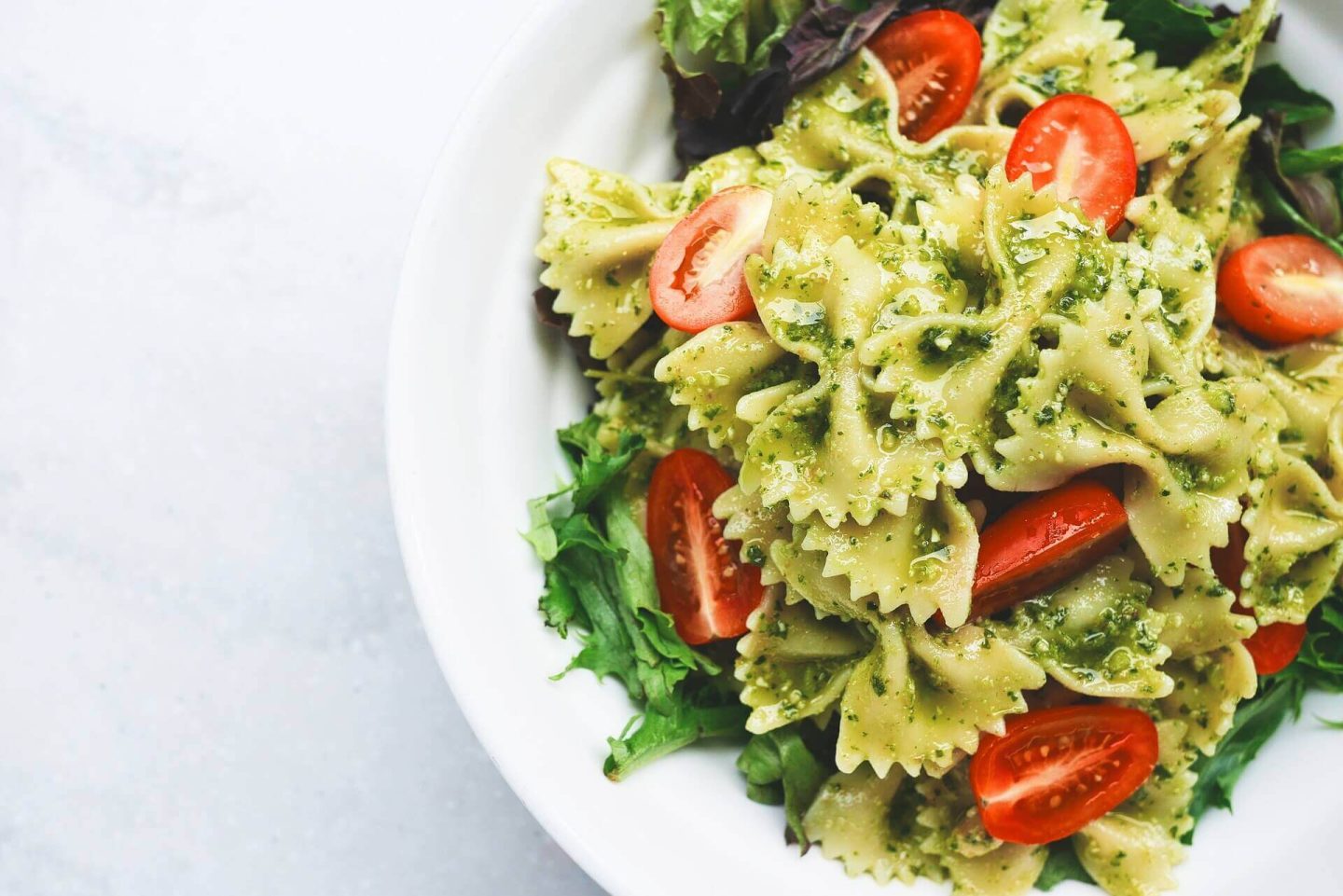 Farfalle with green pesto, tomatoes and arugula